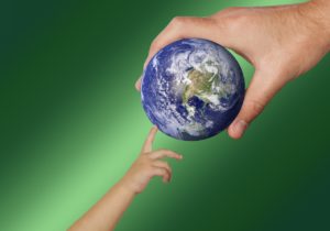 collabora con cosmesinice mano di bimbo e di un adulto che toccano la terra con un dito